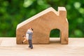 Miniature happy couple family standing with wooden house as prop Royalty Free Stock Photo