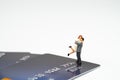 Miniature happy couple holding each other standing on pile of credit card on white background with copy space, success family