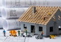 Miniature house construction with tiny workers and blueprints Royalty Free Stock Photo