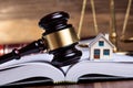 Miniature House And Gavel On Open Book