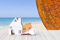 Miniature house with key and old Chinese Feng Shui compass plate over blurred beach background Royalty Free Stock Photo