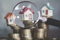 Miniature of house with magnifying glass and coin, choice of location for the construction, of mortgage, rental housing, House