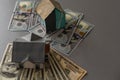 Miniature house model with banknotes on a wooden table, selective focus. Home loan concept. Royalty Free Stock Photo