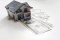 Miniature house model with banknotes on a wooden table, selective focus. Home loan concept. Royalty Free Stock Photo