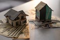 Miniature house model with banknotes on a wooden table, selective focus. Home loan concept. Royalty Free Stock Photo