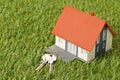 Miniature house model with keys on green grass lawn background - house building or buying concept Royalty Free Stock Photo