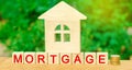 Miniature house and money. Wooden blocks and the inscription `mortgage`. credit for property / apartment. Business loans for real
