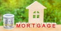 Miniature house and money. Wooden blocks and the inscription `mortgage`. credit for property / apartment. Business loans for real