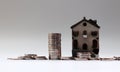 A miniature house and a pile of coins. The concept of real estate investment costs.