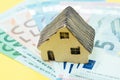 Miniature house on pile of Euro banknote money using as mortgage, real estate investment, home loan or buy and sell house concept Royalty Free Stock Photo