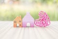 Miniature house with pink heart over blurred green garden background, outdoor day light Royalty Free Stock Photo