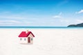 Miniature house with red roof on tropical sand beach over blurred clear sky on day noon light.Image for property real estate inves Royalty Free Stock Photo