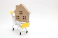 Shopping cart and house on white background. Concept of buying new house, real estate and home mortgage. Royalty Free Stock Photo