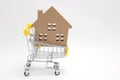 Shopping cart and house on white background. Concept of buying new house, real estate and home mortgage. Royalty Free Stock Photo