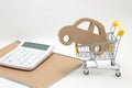 Miniature house, shopping cart and calculator on white background. Concept of buying new house, real estate and home mortgage. Royalty Free Stock Photo