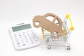 Miniature house, shopping cart and calculator on white background. Concept of buying new house, real estate and home mortgage. Royalty Free Stock Photo