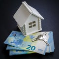 Miniature house of white colour, money and keys as an illustration of the process of buying a home Royalty Free Stock Photo