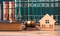 Miniature House on wooden table and judge gavel Royalty Free Stock Photo