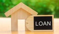 Miniature house with the word Loan. The concept of mortgage housing and real estate loans. Buy an apartment on credit. Leasing. Royalty Free Stock Photo