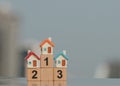 Miniature houses on wooden block number one two three using as business and property concept. Royalty Free Stock Photo