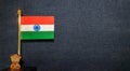 Miniature Indian National Flag on a metal stand with national emblem 'Ashok Stambh' on blue canvas background.
