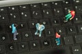 Miniature little people, group of friends over a computer keyboard, in a blurred background top view Royalty Free Stock Photo