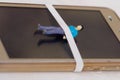 Miniature little people, prisioner over a screen of a tablet, in a white background