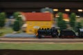 Miniature locomotive train speeding on a train track with motion blur