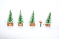 Miniature lover couple with background small artifician Christmas tree on nature wooden table and wood sled on white background,