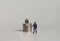 A miniature man reading on a coin and a miniature policeman holding a megaphone. Royalty Free Stock Photo