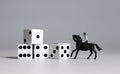 Miniature man riding a horse and white dice. Concepts about the probability of winning a race.