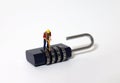 A miniature man standing on a unlocked combination lock. Royalty Free Stock Photo