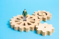 A miniature man is stands on the gears. The concept of the business process, the generation of ideas and plans. Royalty Free Stock Photo