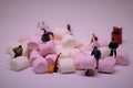 Miniature men showing `Teamwork` concept with marshmallows Royalty Free Stock Photo