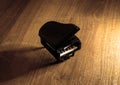 Miniature model of black grand piano with shadow