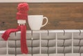 Miniature model house with knitted cap and scarf on heating radiator. Space for text. Saving heating in winter Royalty Free Stock Photo