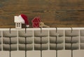 Miniature model house with knitted cap and scarf on heating radiator. Space for text. Saving heating in winter Royalty Free Stock Photo