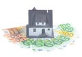 Miniature model of houses on stacked euro banknotes, on isolated white background. Real estate investment concept. Saving money fo Royalty Free Stock Photo