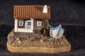 miniature model of a small house with a boat beside it, under a dark night background. Royalty Free Stock Photo