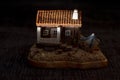 miniature model of a small house with a boat beside it, under a dark night background. Royalty Free Stock Photo