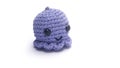 Miniature octopus keychain in purple colors crocheted on a white background