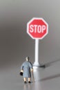 Miniature of an aged lady looking at a stop sign