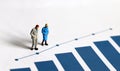 A miniature older people standing on a blue bar graph.