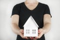 Miniature paper house in the hands of a woman. Isolated