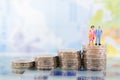 Miniature people, adult couple figure standing on top of stack coins . Image use for background retirement planning, Life insuranc Royalty Free Stock Photo