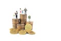 Miniature people as family, couple and businessman place on pile heap stacked silver and golden coins. Royalty Free Stock Photo