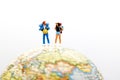 Miniature people, backpackers on the globe walking to destination. travel and business concept.