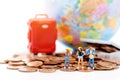 Miniature people, backpackers standing on stack of coins