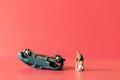 Miniature people broken leg man patient with bandage walking with crutch with toy car wreck