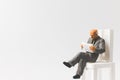 Miniature people business concept sitting on chair with a space Royalty Free Stock Photo